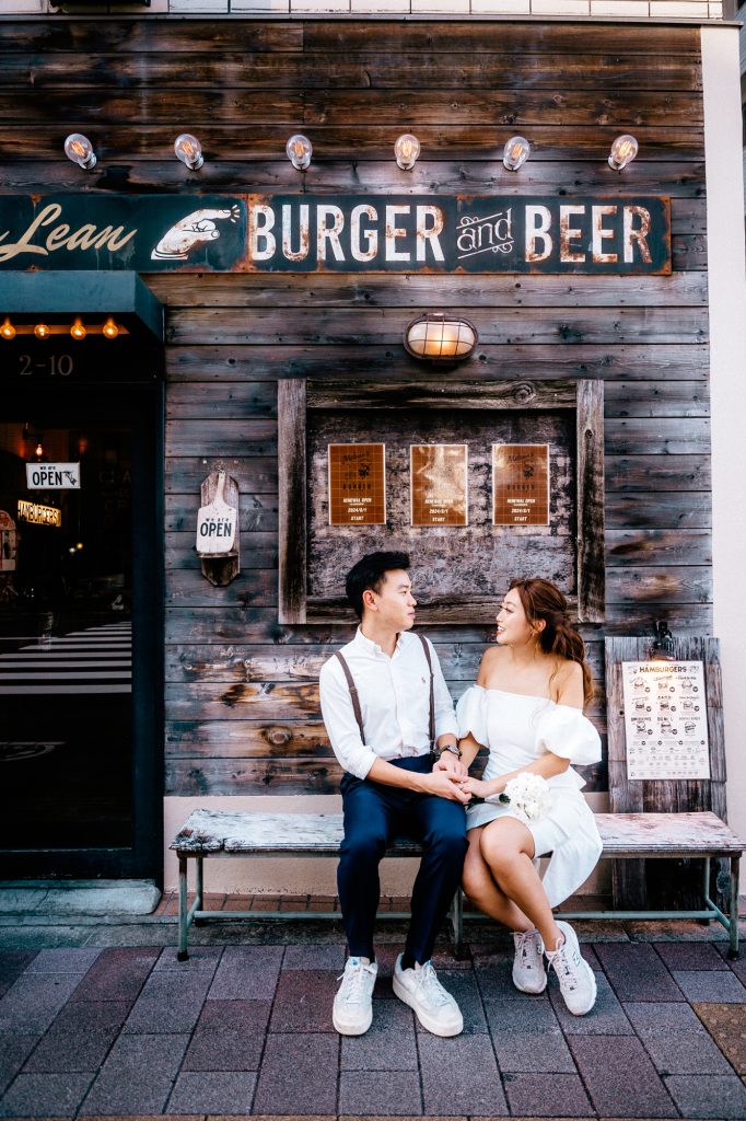 蔵前のバーガー店の前のベンチに座る前撮りカップル写真