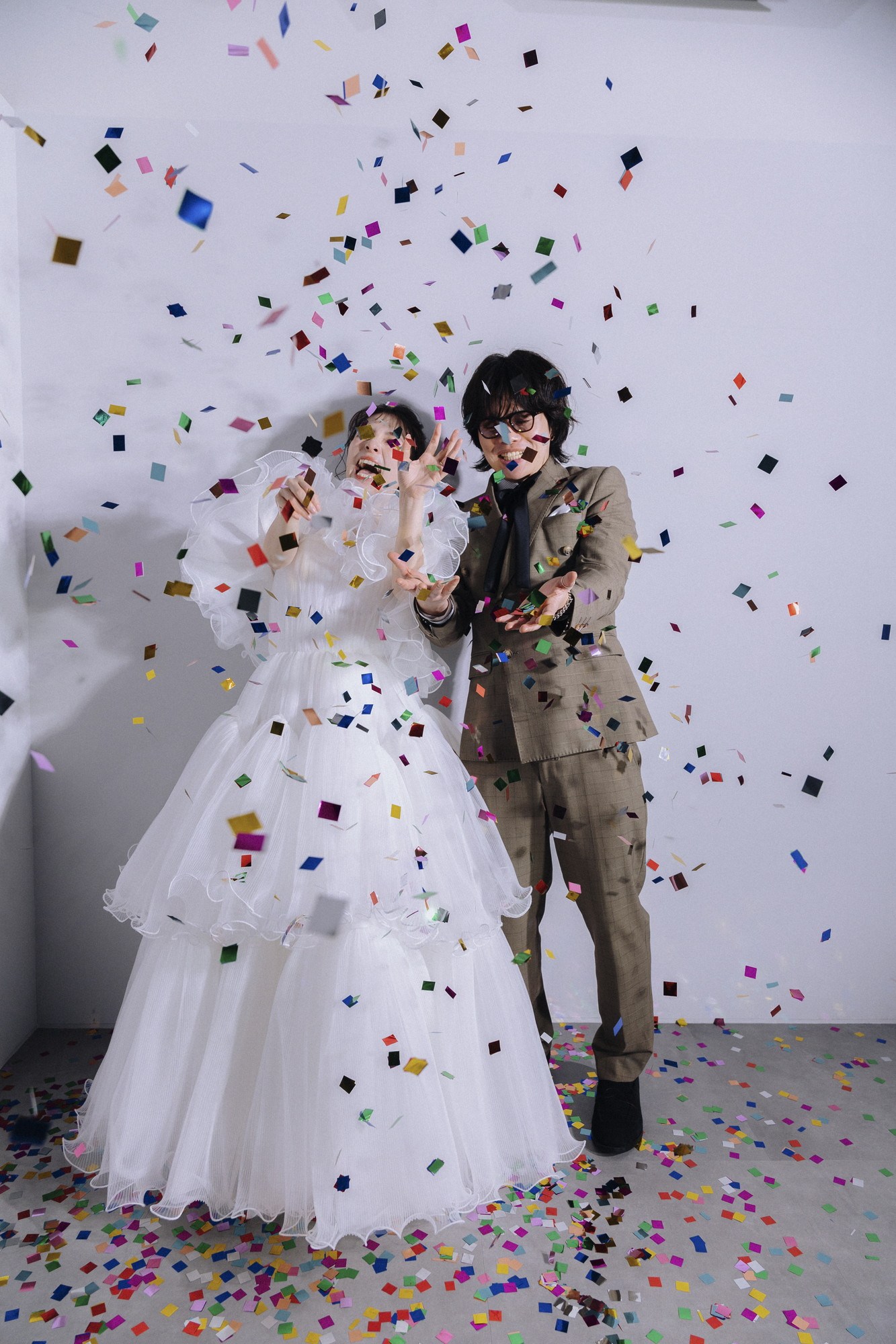 紙吹雪の中で笑うおふたり。Dress Curre着用の実際のお客さま