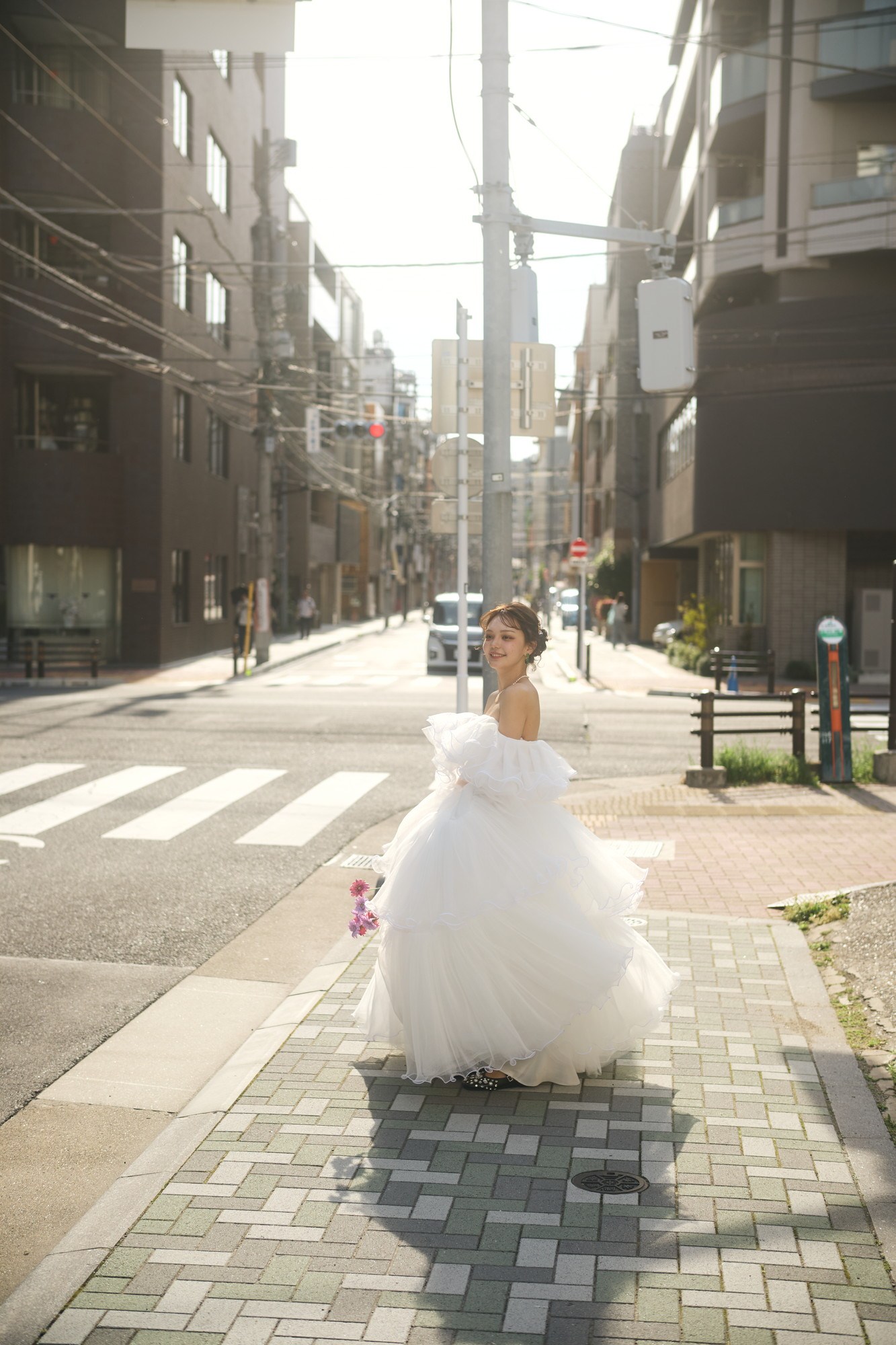 街の道路でドレスの裾を広げて走る前撮り