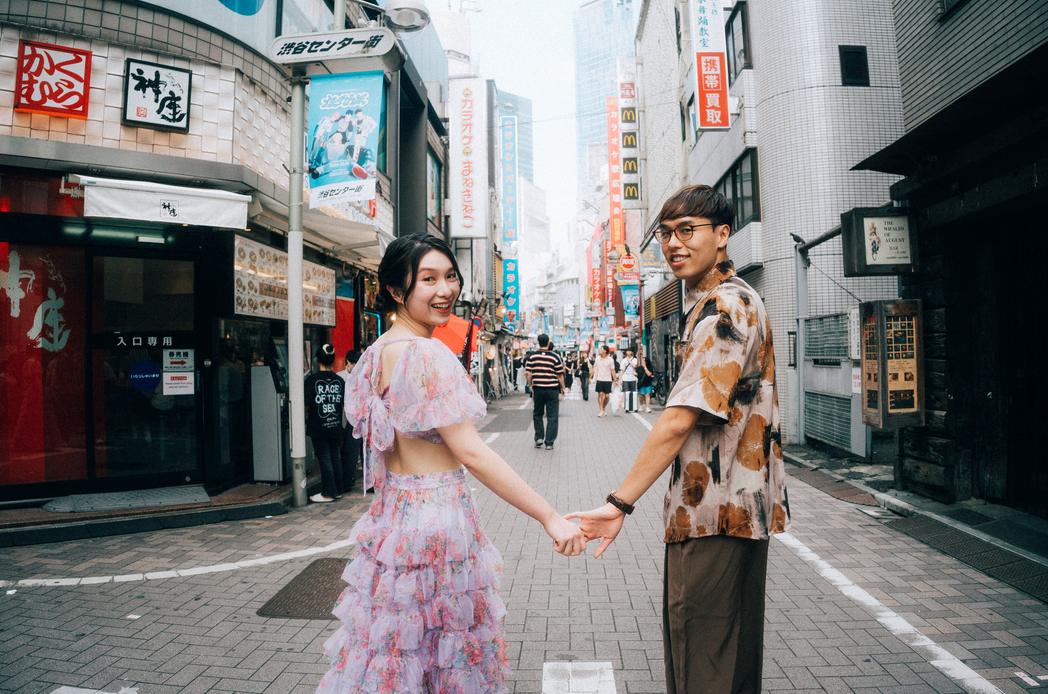 渋谷の商店街で向かい合って手をつなぐカップル