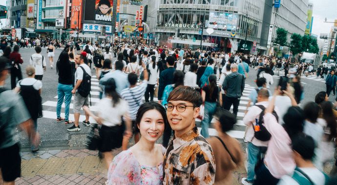 渋谷スクランブル交差点を渡る人波の中のカップル