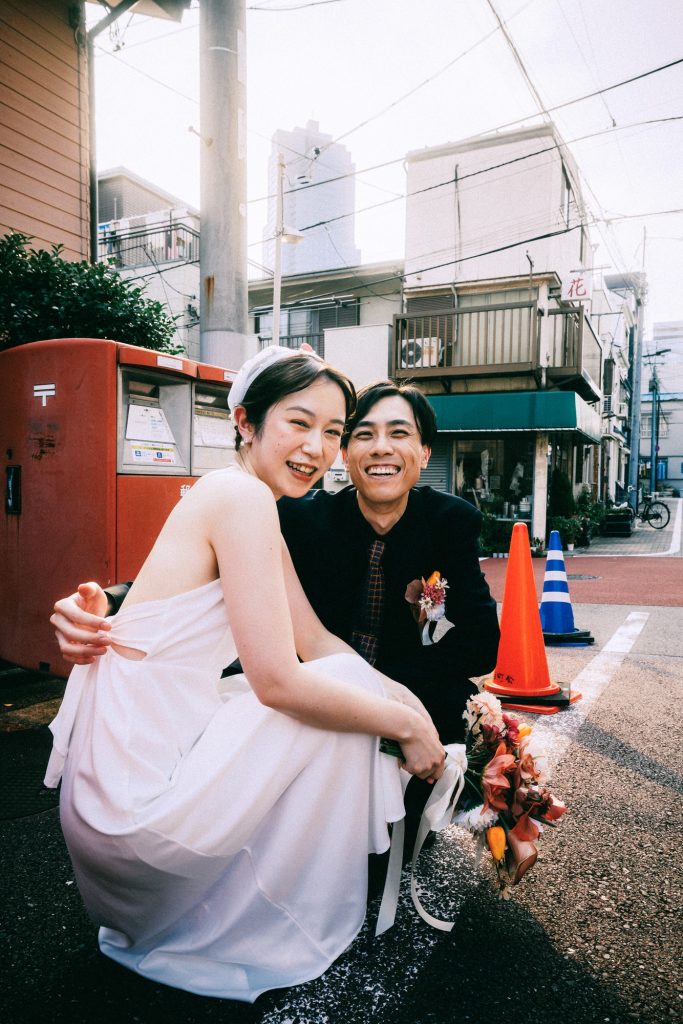 赤い郵便ポストの前でしゃがむ新郎新婦｜月島前撮り