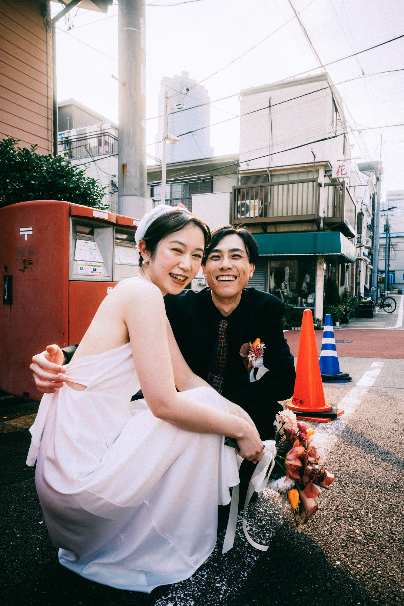 Pengantin berjongkok di depan kotak pos merah | foto prewedding Tsukishima